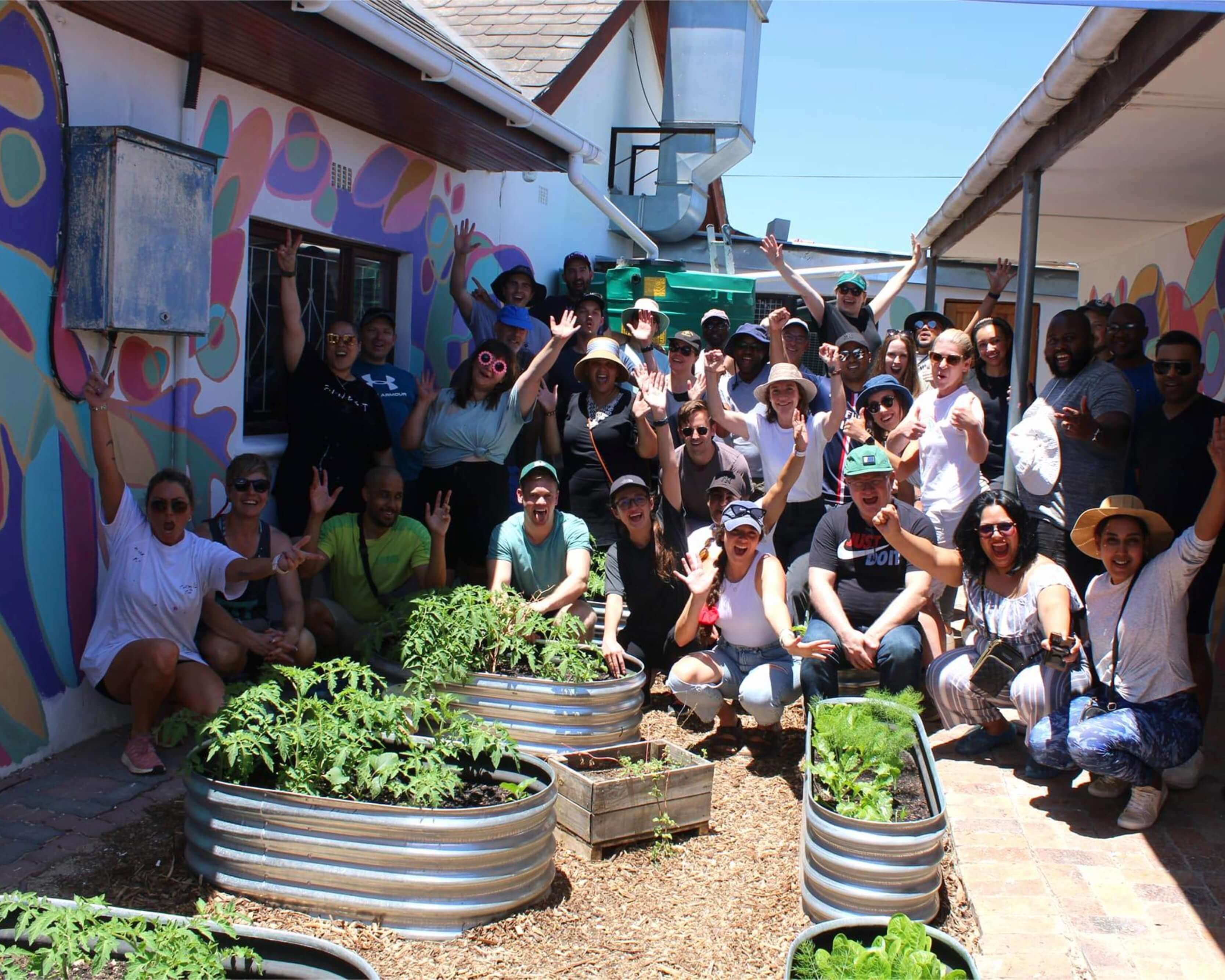 A group of people waving in front of vegetation